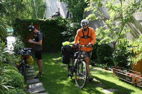 a man in an orange shirt riding a bike in the grass at Base for Adventurers - Urban Guerrilla in Negotin