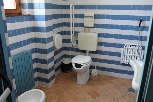 a bathroom with a toilet with blue and white stripes at Ostello Europa in San Vito al Tagliamento