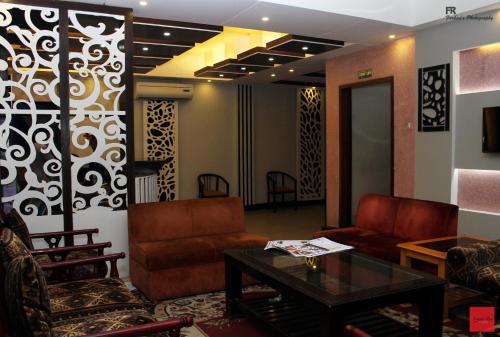 a lobby with couches and a table and chairs at Nagar Valley Hotel Ltd. in Dhaka