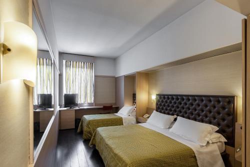 a hotel room with two beds and a window at Viva Hotel Avellino in Avellino