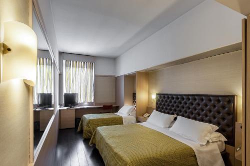 um quarto de hotel com duas camas e uma janela em Viva Hotel Avellino em Avellino