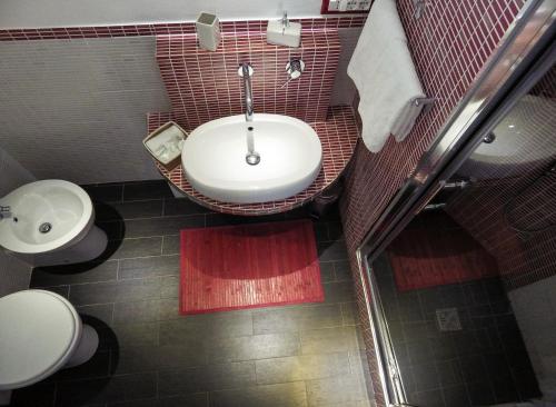 a bathroom with a white sink and a toilet at B&B Le Vele in Maruggio