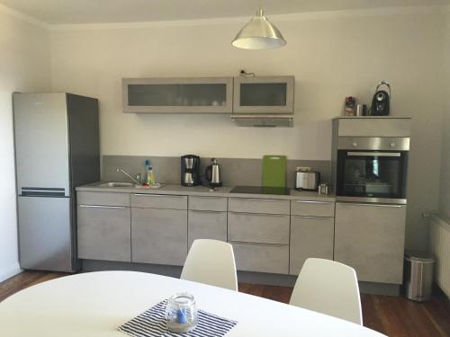 a kitchen with a refrigerator and a table and chairs at Haus Sonnenschein in Boltenhagen