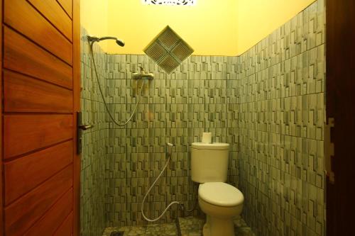 a bathroom with a toilet and a shower at Edy Homestay in Munduk