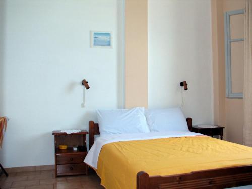a bedroom with a bed with a yellow blanket at MARIA Studios & Apartments in Agios Ioannis Pelio