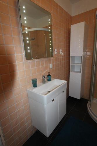 La salle de bains est pourvue d'un lavabo blanc et d'un miroir. dans l'établissement Rabac 1, à Rabac