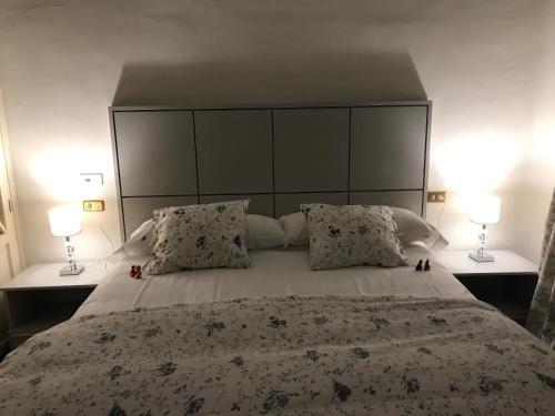a bedroom with a large bed with two lamps at Casa Palacio VillaZambra in Ronda