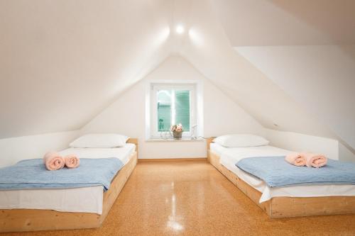 two beds in a attic room with a window at Split Inn Apartments in Split