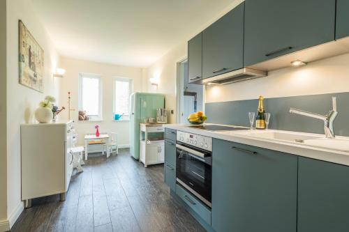 a kitchen with blue cabinets and a sink at Villa Scandic Apartments in Rust