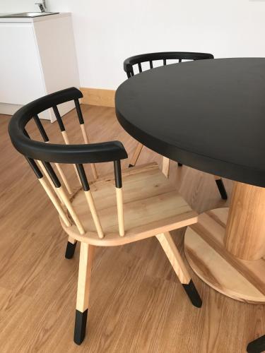 a black table and a wooden chair next to a table at Casa da Sé by PURUS in Coimbra