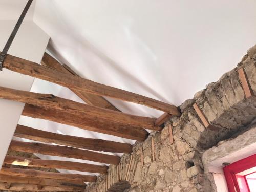 a ceiling with wooden beams in a room at Casa da Sé by PURUS in Coimbra