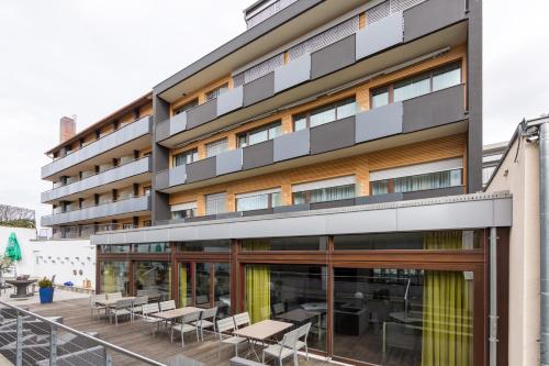 an external view of a building with tables and chairs at Best Western Hotel Würzburg-Süd in Würzburg