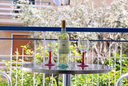 a bottle of wine and two wine glasses on a table at Mongibello Palace B&B in Mondello