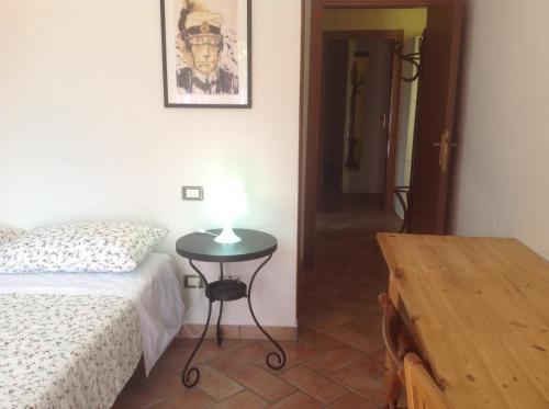um quarto com uma cama e uma mesa com um candeeiro em Villa Giulia em Rimini