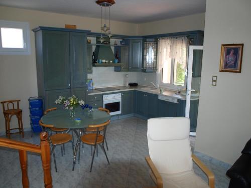 ケラモティにあるKeramoti Villa Magnoliaのキッチン(青いキャビネット、テーブル、椅子付)