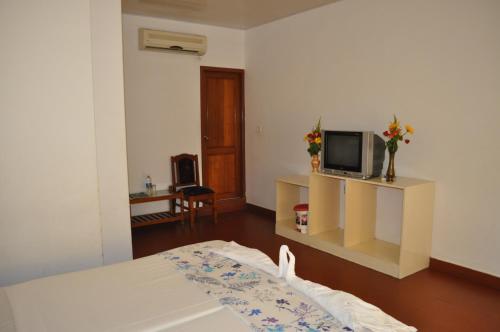a hotel room with a bed and a television at Marine Palace Beach Hotel in Kovalam