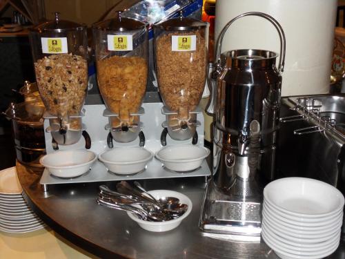 a counter with some cups and bowls on a shelf at Logis Le Midland in Vichy