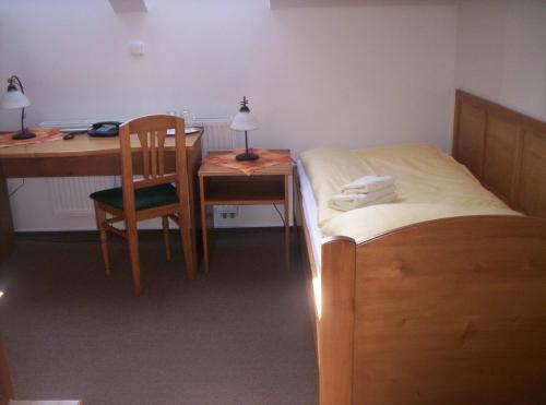 a bedroom with a bed and a desk and a table at Hotel Krakonoš in Trutnov
