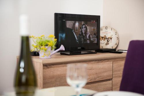 a tv sitting on top of a table with a wine glass at Apartment Simone in Split