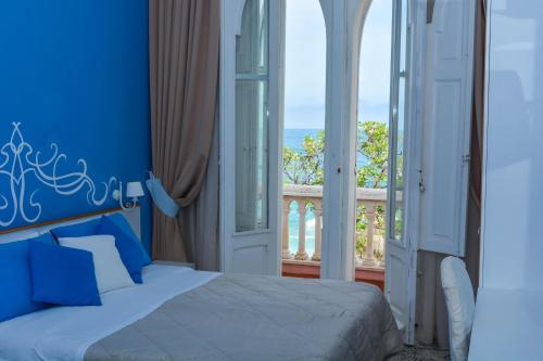 a blue bedroom with a bed and a balcony at B&B Villa Raineri in Giardini Naxos