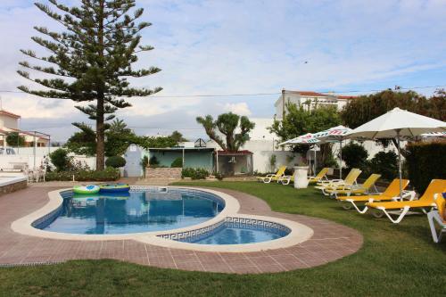 a swimming pool with lounge chairs and an umbrella at Sunshine in Albufeira