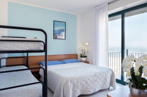 a bedroom with two bunk beds and a balcony at Hotel Emilia in Rimini