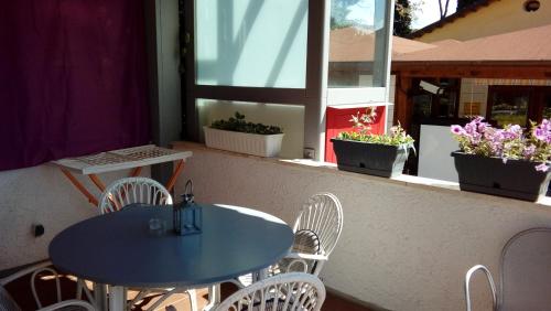 two tables and chairs on a balcony with potted plants at Residence Al Lago in Castiglione del Lago
