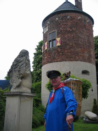 a man standing in front of a building with a statue at Hotel Restaurant Clemens-August in Ascheberg