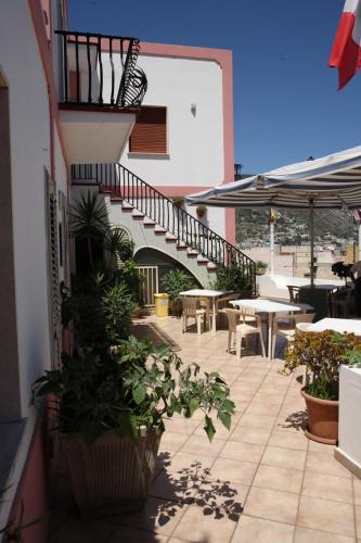 a patio with a staircase and tables and chairs at Baia Unci in Canneto