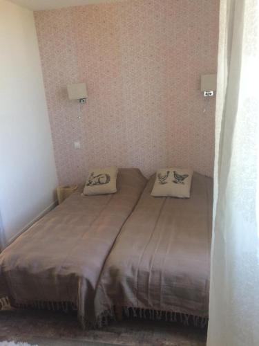 un lit dans une chambre avec deux oreillers dessus dans l'établissement L'ANNEXE, à Carennac