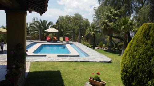 a swimming pool in a yard with trees at Mirador del Frayle in San Miguel de Allende