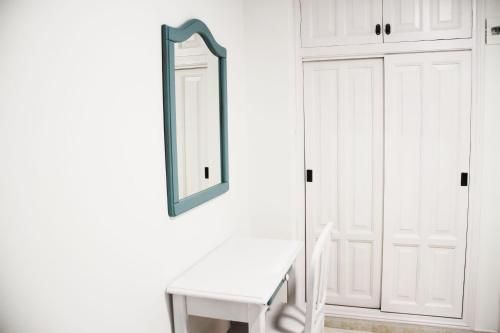 a mirror on a wall next to a white door at Hugo Beach Hotel & Apartments in Gandía