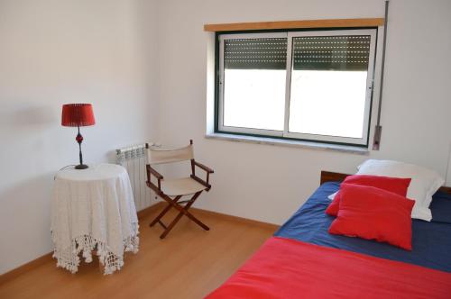 a bedroom with a bed and a table and a window at Apartment Peniche swimming pool in Peniche de Cima