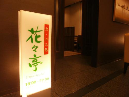 a sign in a hallway with a sign in a building at Hotel Route-Inn Toyotajinnaka in Toyota