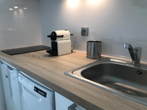 - un comptoir de cuisine avec un évier et un canapé dans l'établissement Appartement Vue Mer Cannes Azur, à Cannes