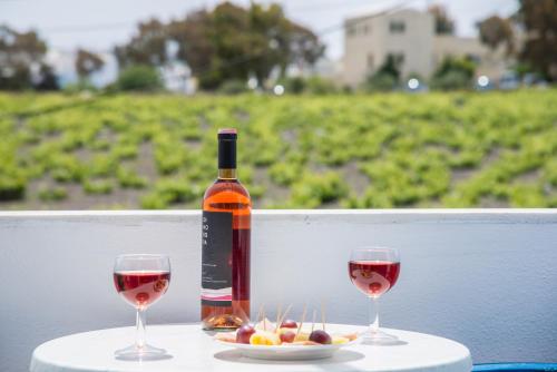 a bottle of wine and two glasses on a table at Hotel Olympia in Karterados