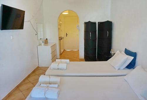 a room with two beds and a tv and a bathroom at Ilios in Skala