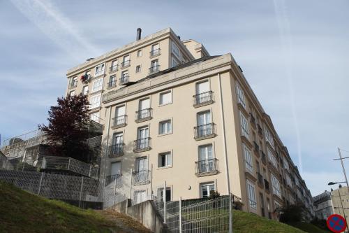 un alto edificio blanco en una colina en Viveiro, en Viveiro