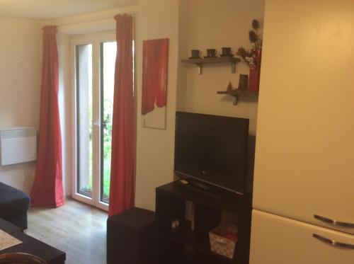 uma sala de estar com uma televisão de ecrã plano e uma janela em Apartment Garden em České Budějovice