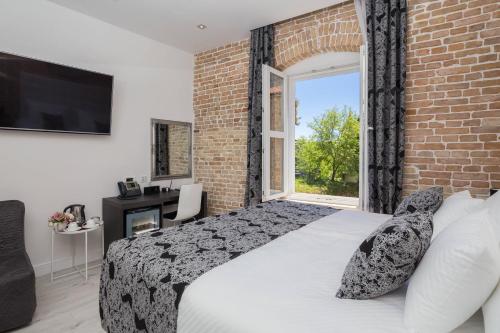 ein Schlafzimmer mit einem Bett und einer Ziegelwand in der Unterkunft Sleep Split in Split