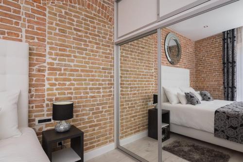 a brick walled bedroom with two beds and a mirror at Sleep Split in Split
