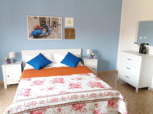 a bedroom with a bed with blue walls and white cabinets at Near To Pisa Airport Guesthouse in Pisa