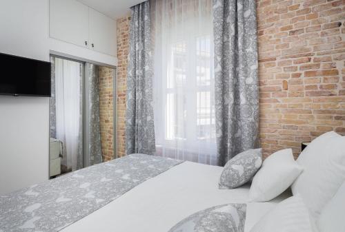 a bedroom with a white bed and a brick wall at Sleep Split in Split