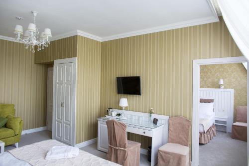 a bedroom with a desk and a bed and a tv at Boutique Hotel Deluxe in Kamianets-Podilskyi