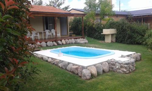 una piscina in un cortile con rocce intorno di Cabañas Cumelen a Potrero de los Funes