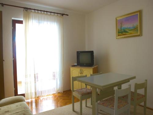een woonkamer met een tafel en een televisie bij Nada Apartments in Poreč