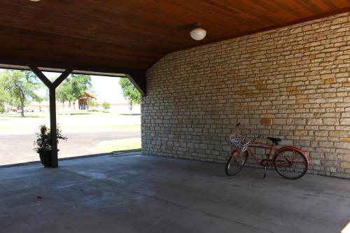 a red bike parked next to a brick wall at Live Oak B&B in Glen Rose