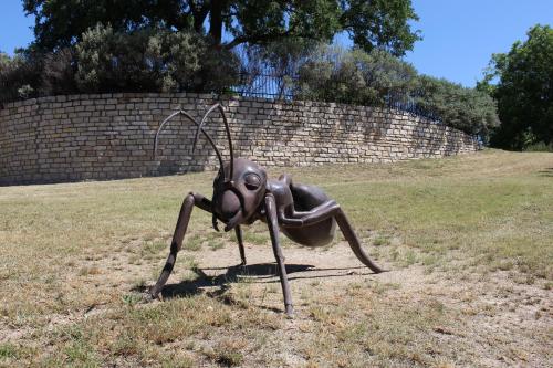 a statue of a bug standing in a field at Live Oak B&B in Glen Rose