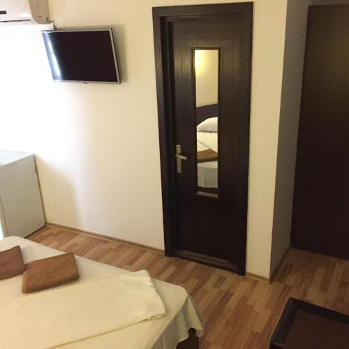 a room with two beds and a black door at Vila DG in Mamaia Nord