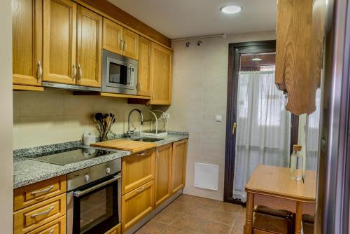 a kitchen with wooden cabinets and a sink and a stove at Casa Sollevante in Sesué